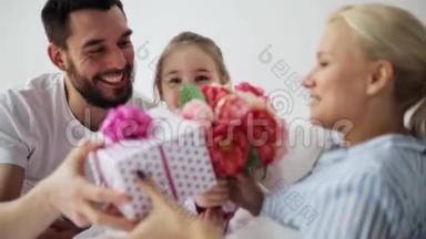 一家人在床上给母亲送花和礼物